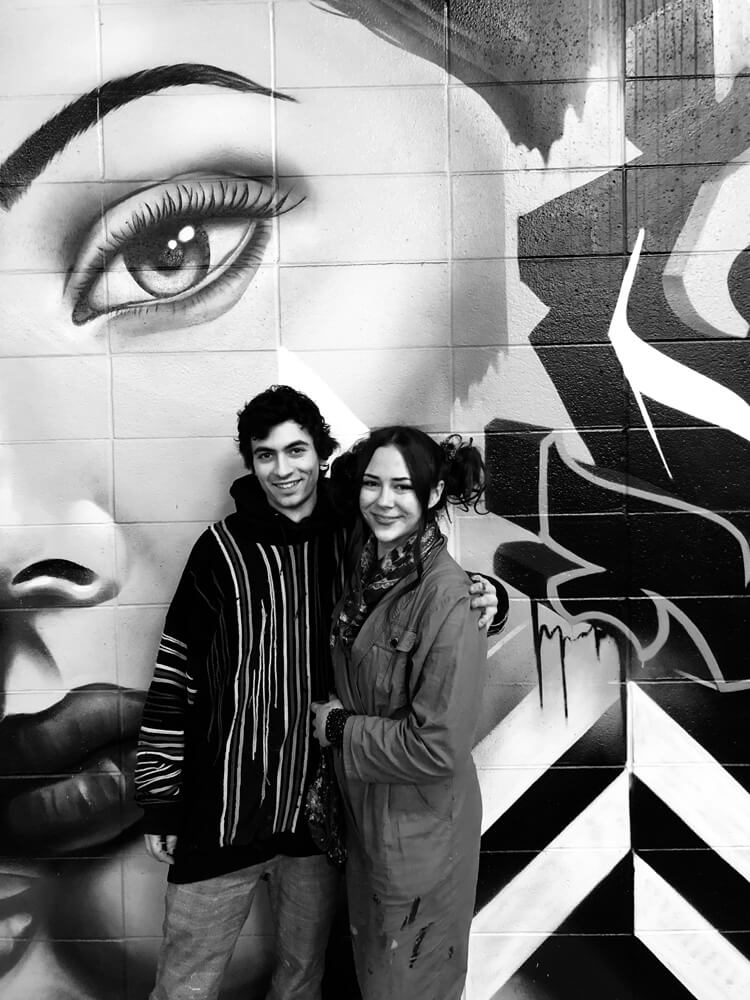 couple standing in front of graffiti art