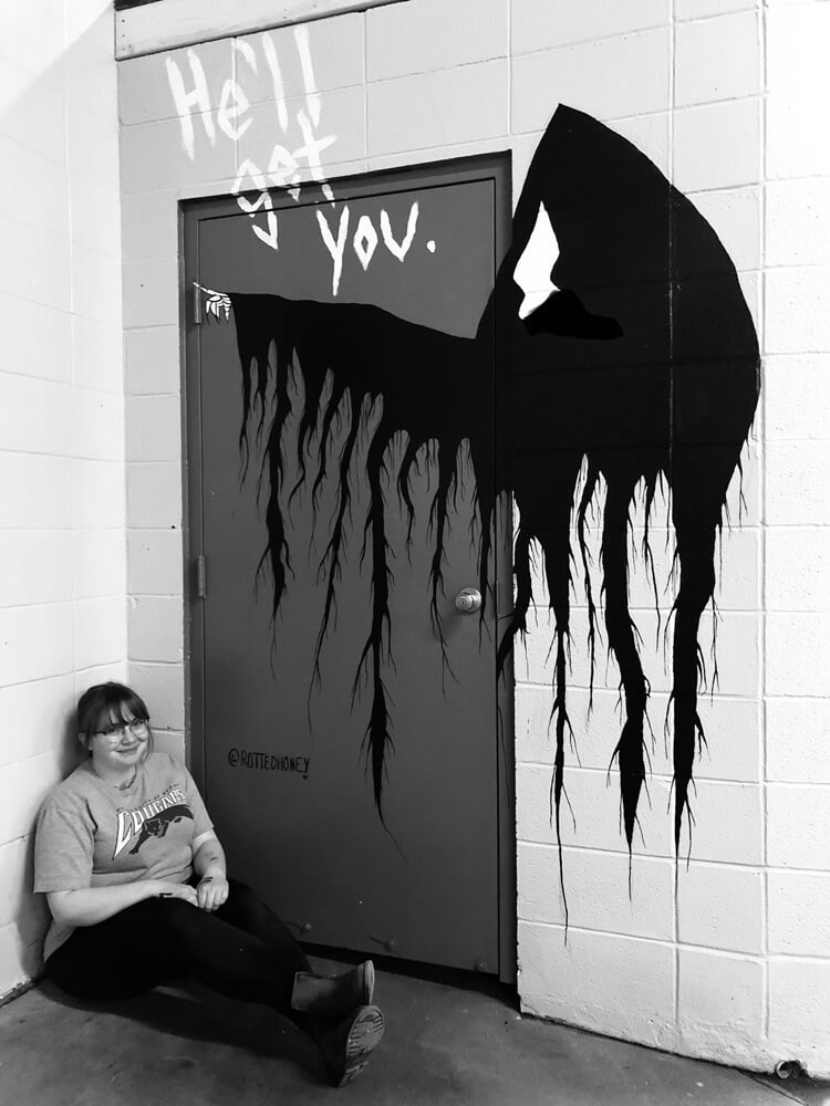 woman sitting in front of graffiti art at Arthur's Car Wash